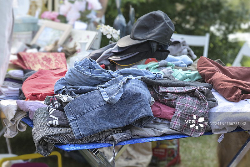 跳蚤市场或车库市场出售的旧衣服和帽子，阳光明媚的周末图片素材