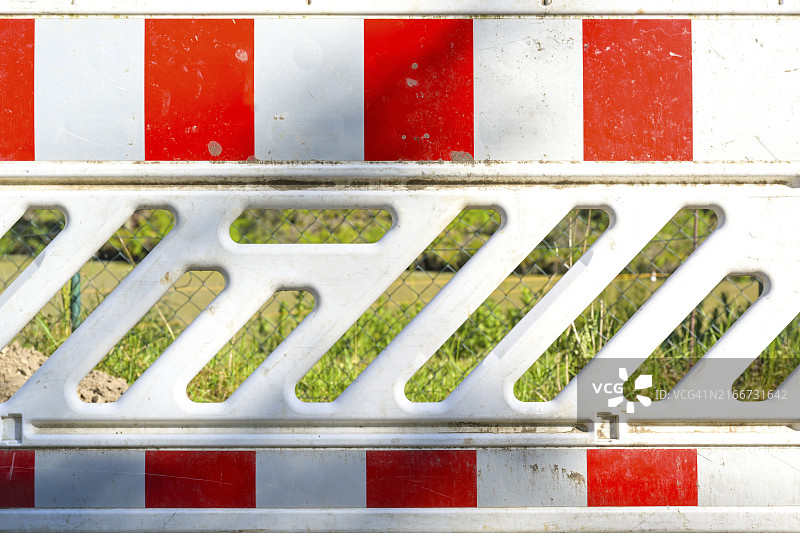 阳光明媚的土方工程安全措施：红白色交通护栏图片素材