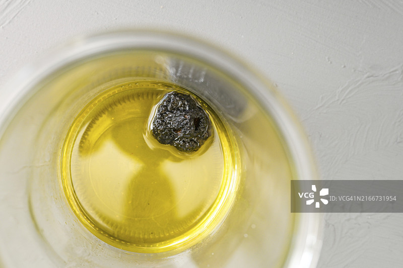放在玻璃罐中橄榄油里数天的黑松露，用于自制松露油，高角度俯视，复制空间，选择焦点，窄景深图片素材