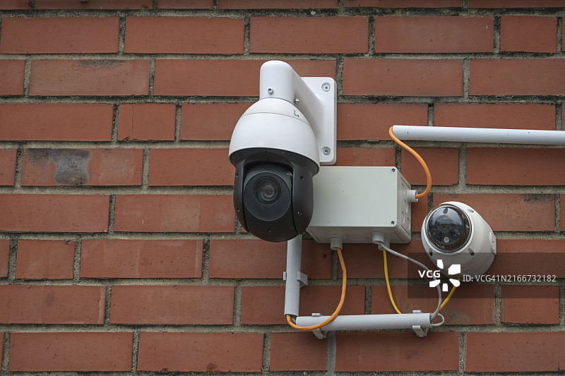 红砖墙上的监控摄像头系统图片素材