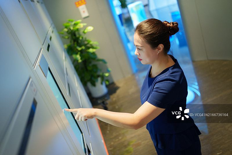 亚洲女人使用自助储物柜图片素材