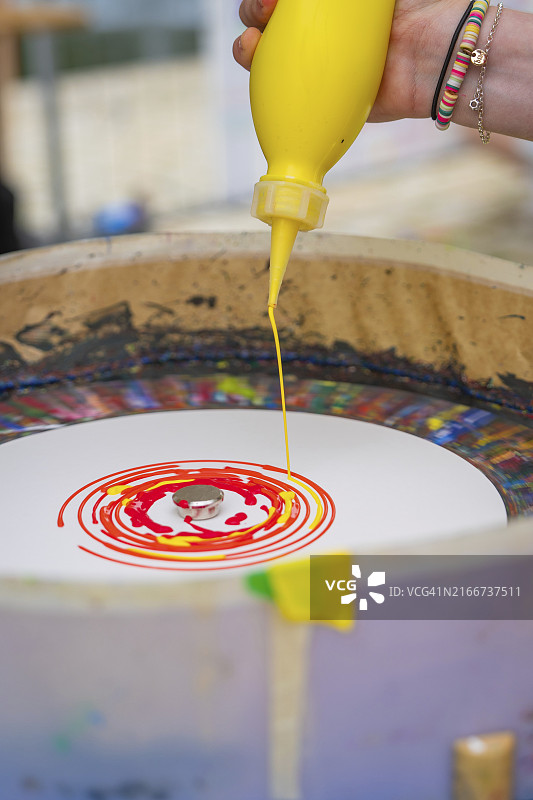 手持黄色瓶子，将颜料滴入螺旋图案，德国黑森林，欧洲图片素材