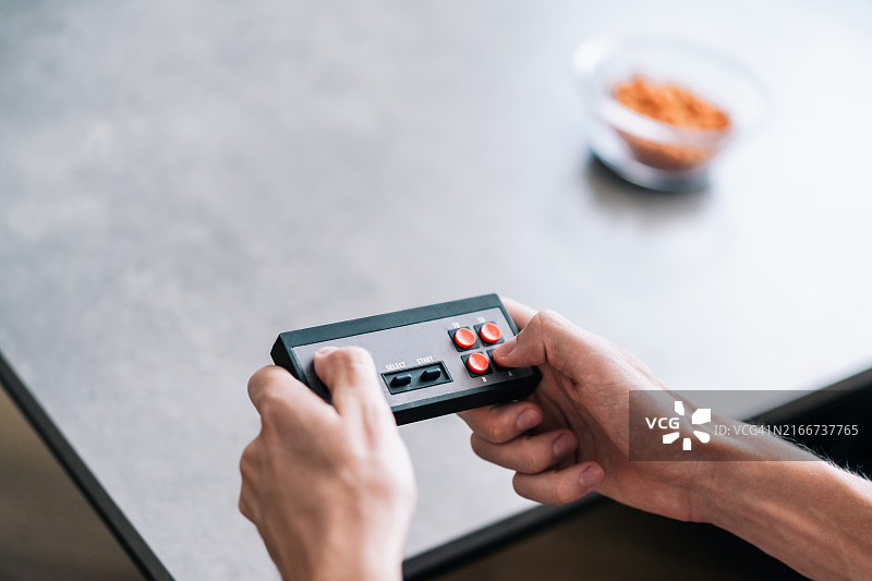 手中的复古游戏手柄特写图片素材