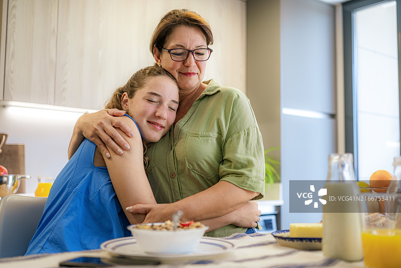 温馨的母女在早餐时拥抱图片素材