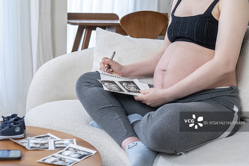 孕妇看着超声波图像时做笔记图片素材