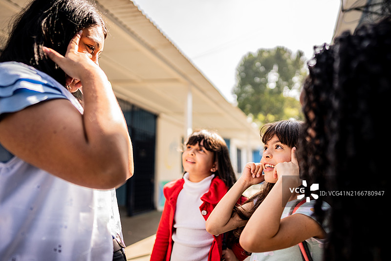 老师在校园里和学生们一起玩耍图片素材