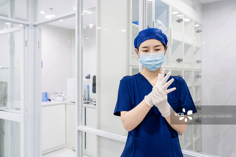 女性牙医助理在诊所戴防护手套准备工作肖像图片素材
