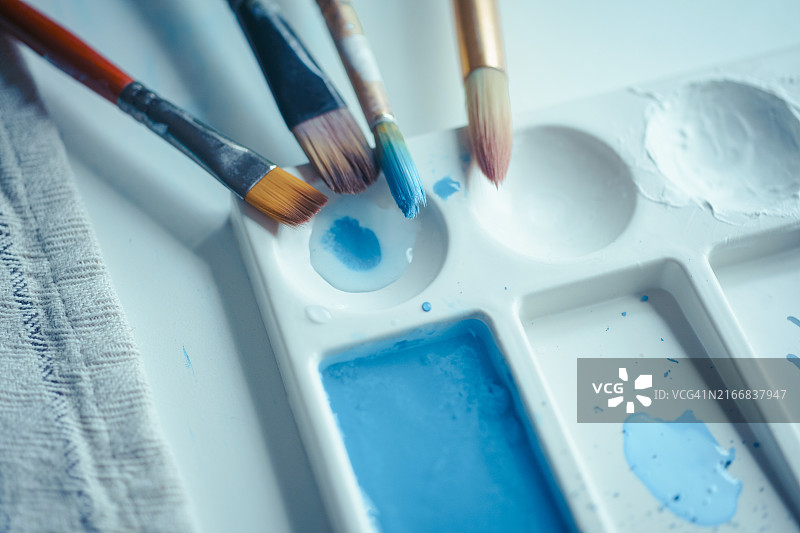 蓝色油漆调色板上的画笔图片素材