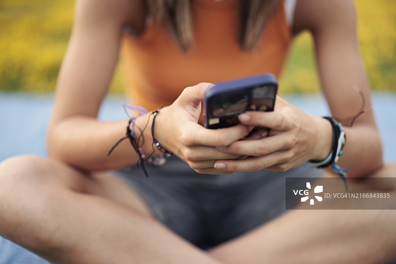 少女坐在花草草坪上的毯子上图片素材