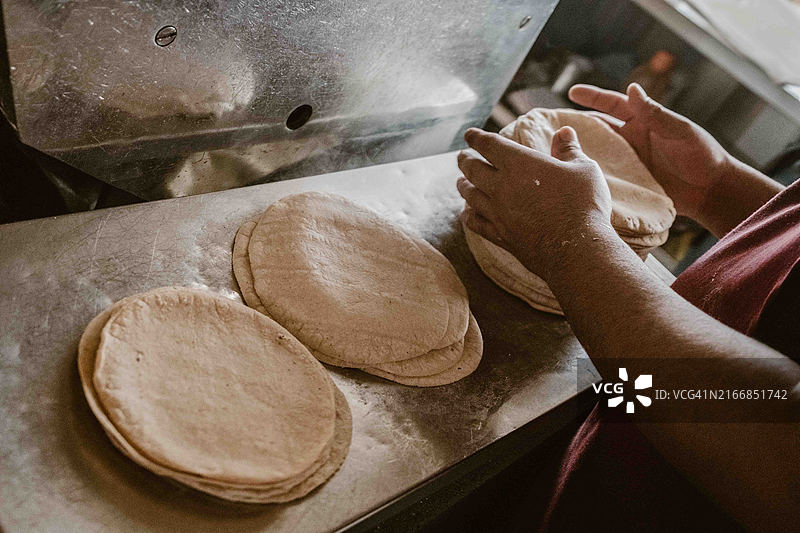一人堆叠新鲜的玉米饼图片素材