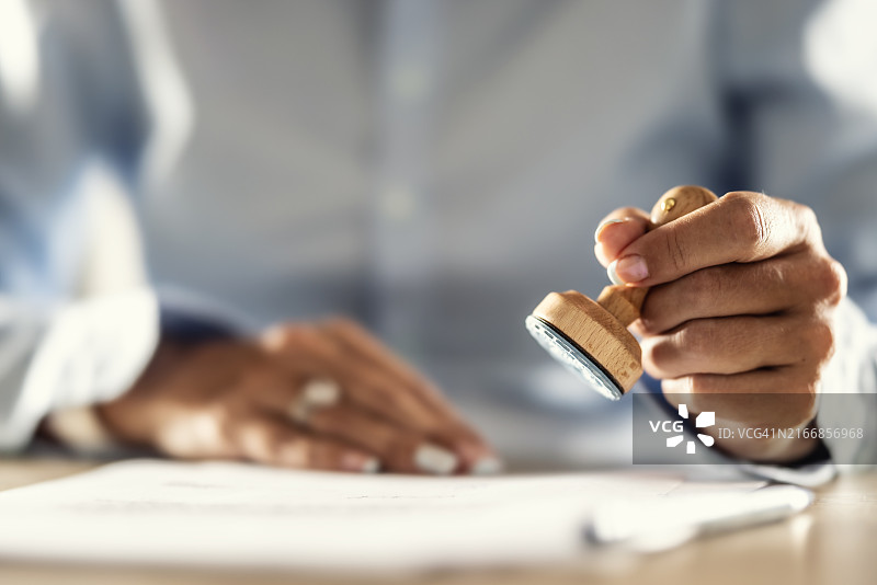 公证处助理在已存档的文件上盖章图片素材