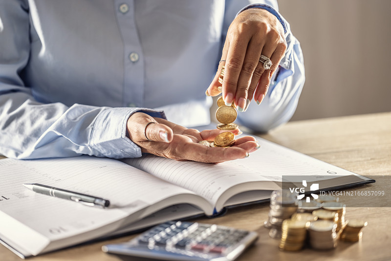 金融会计象征性地将金币从一只手倒入另一只手图片素材