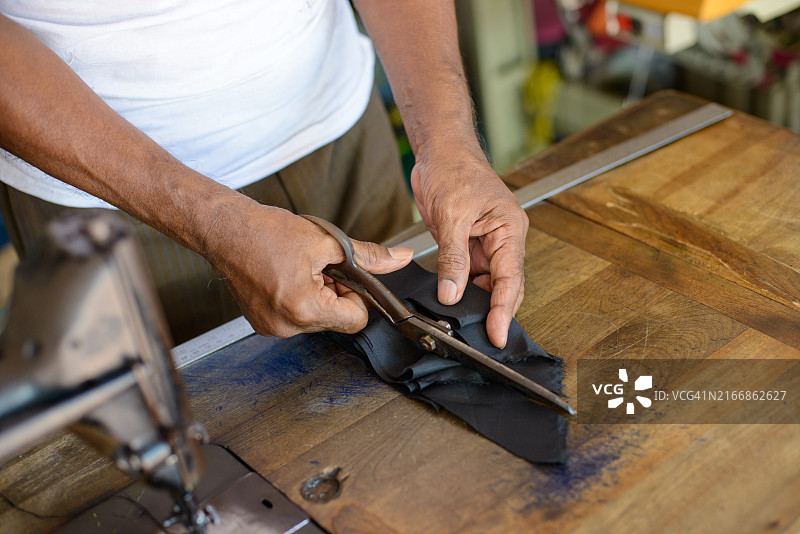 剪刀裁剪制作宋谷帽的黑色布料图片素材