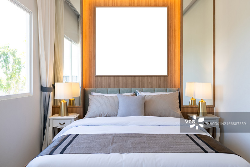 带空白画框和柔和灯光的现代卧室图片素材