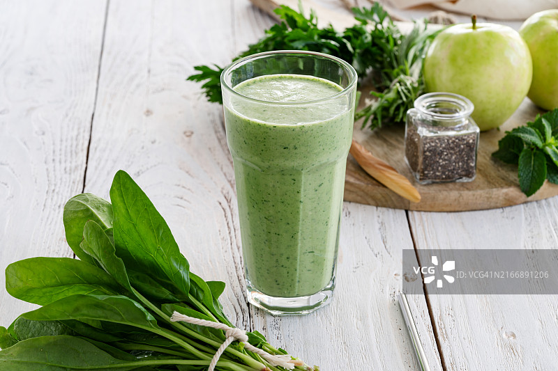 含新鲜叶类蔬菜、水果、香草和奇亚籽的绿色冰沙图片素材