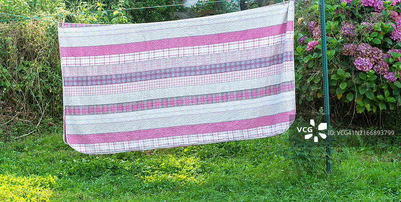 挂在户外晾衣绳上的毯子图片素材