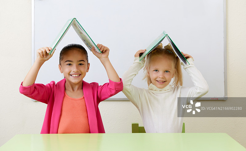 学龄前儿童在桌旁看书图片素材