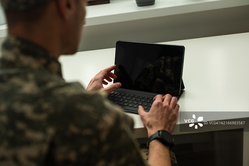 穿军装的白人士兵在电脑前感到高兴图片素材