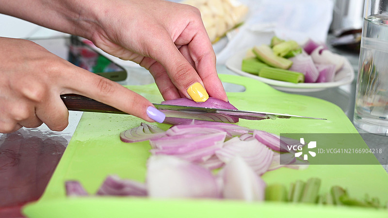 切洋葱特写：女性的手切红色洋葱图片素材