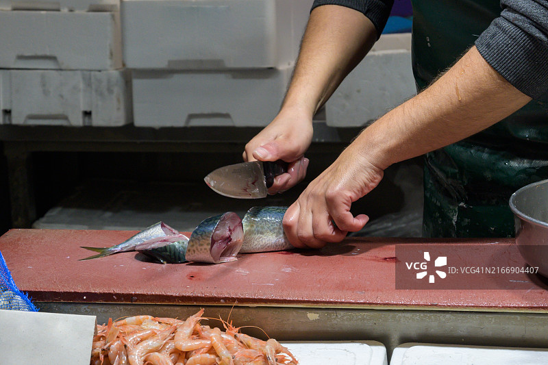 市场工人用刀切鱼特写图片素材