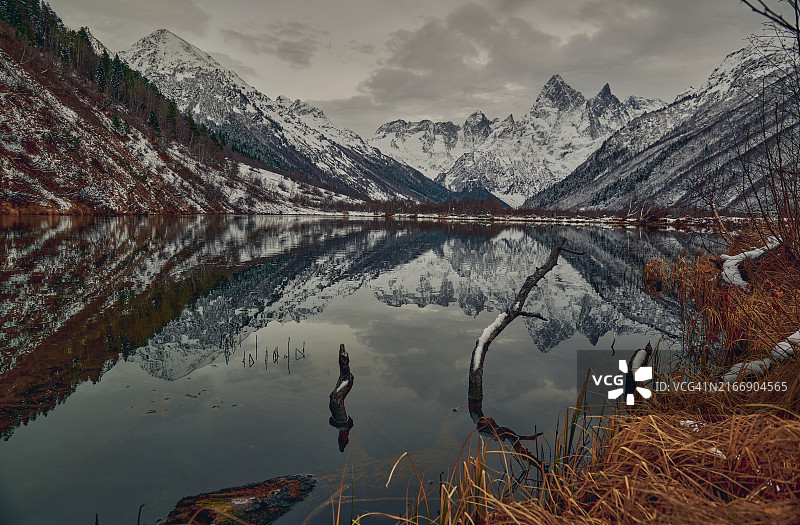 白雪皑皑的群山映衬着天空，湖边景色优美图片素材