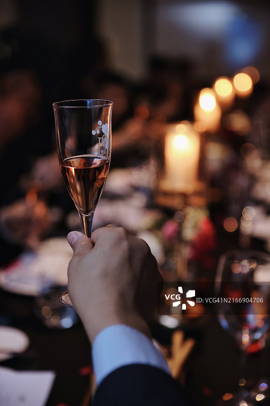 男人的手部特写：手持酒杯准备讲话图片素材