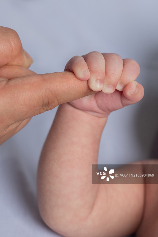 父母握着婴儿的手的局部图图片素材