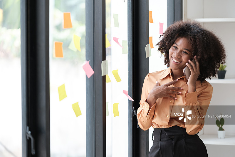 非裔美国女员工在彩色便利贴上记录管理列表，专注图片素材