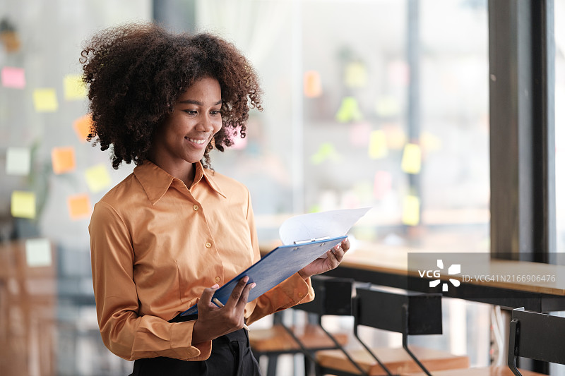 非裔美国女员工在彩色便利贴上记录管理列表，专注图片素材