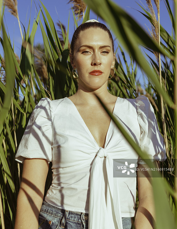 站在植物前的年轻女子肖像，美国伊利诺伊州芝加哥图片素材