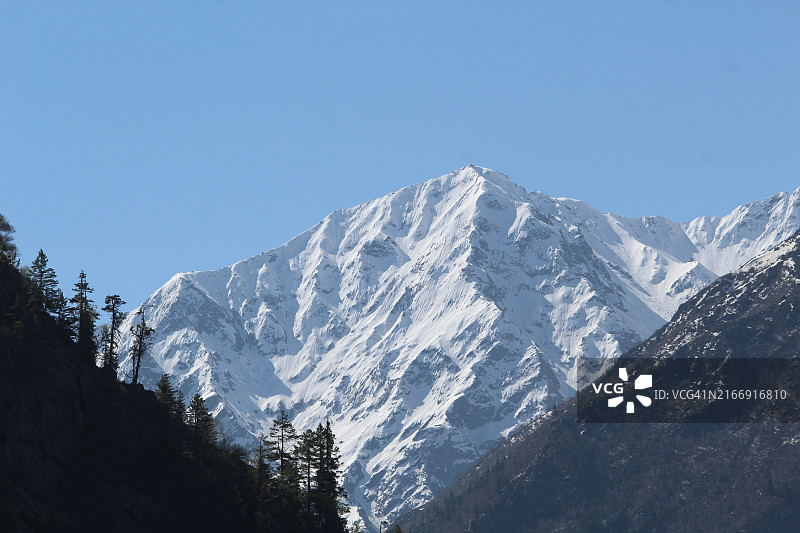 白雪皑皑的群山映衬着晴朗的天空图片素材