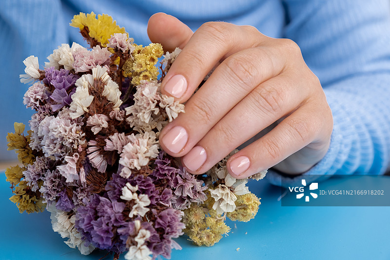 蓝色背景上柔和的淡色系美甲图片素材