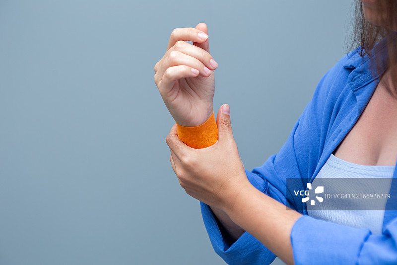 女性手部特写摄影：手腕疼痛并缠绕弹性绷带图片素材