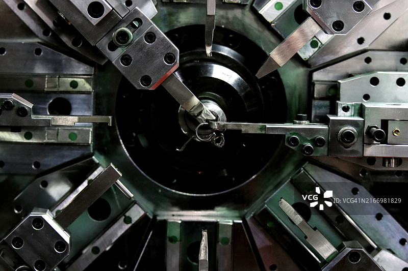 特写：弹簧卷绕机，机械零件制造概念图片素材