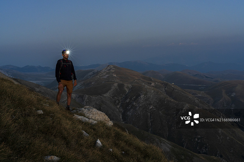 黎明时分戴着头灯的徒步者，意大利图片素材
