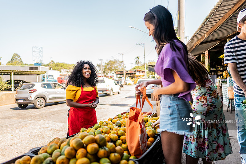 在街头市场与顾客交谈的女售货员图片素材