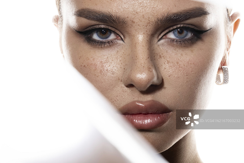 拥有异色症的年轻女人的肖像，蓝色和棕色眼睛，高质量的摄影作品图片素材
