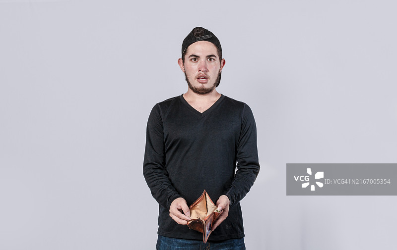 看着空钱包不开心的惊讶的男人图片素材