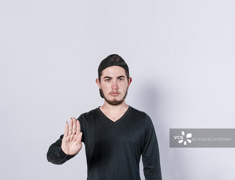 手持停止标志的严肃年轻人图片素材