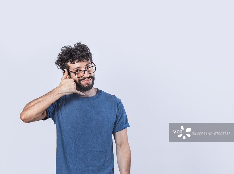 穿着休闲的年轻白人男子模仿打电话图片素材