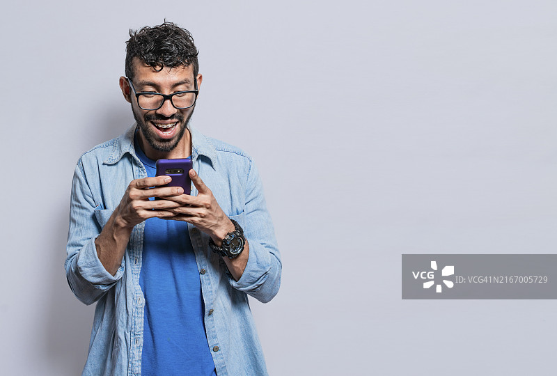 快乐的年轻男子用手机发短信图片素材