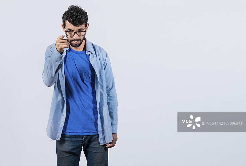 生气男人指着摄像头发出威胁。愤怒的人正面威胁的概念图片素材