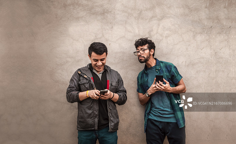 男人偷看另一个人手机，八卦的男人偷看朋友手机图片素材