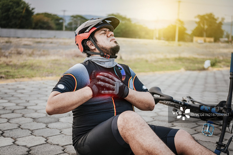 在人行道上胸痛的骑行者图片素材