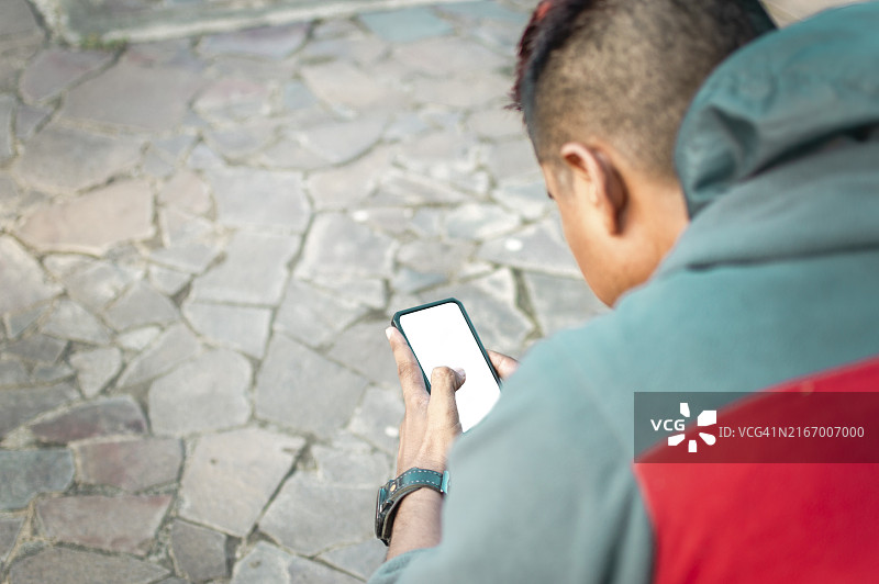 男子坐着，用智能手机查看短信图片素材