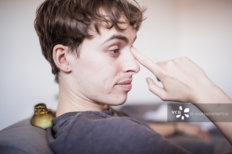 午后阳光下触摸鼻子的瞬间：人物摄影图片素材