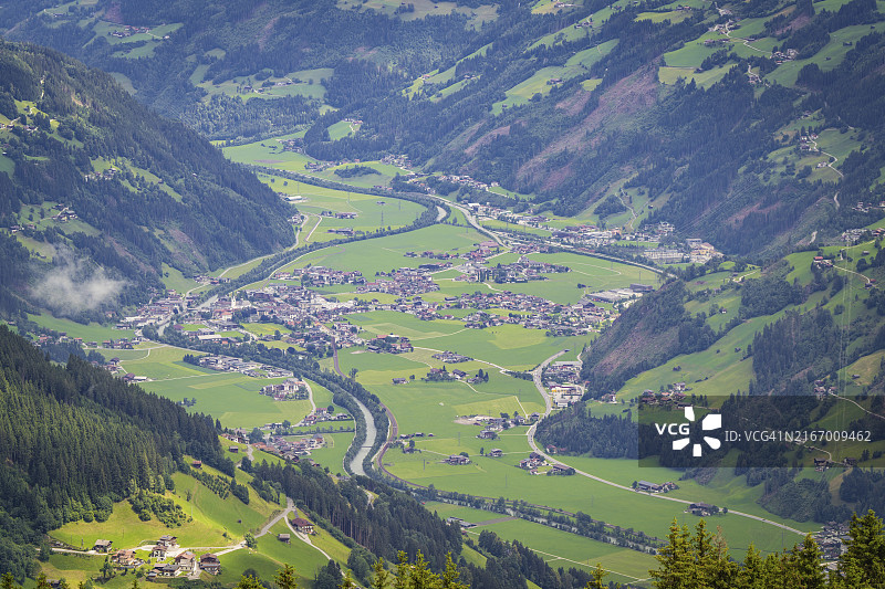 阿尔卑斯山绿谷村庄河流，被群山环绕，奥地利图片素材