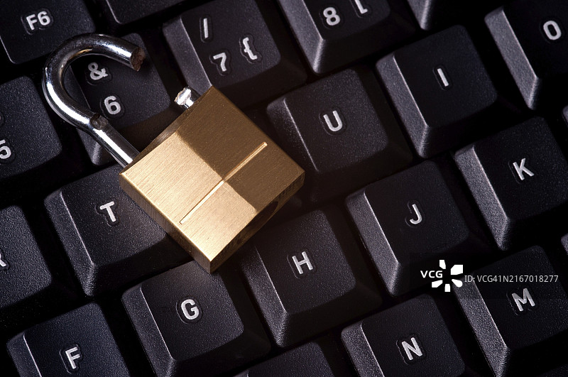 电脑键盘上的破损挂锁，代表电脑安全漏洞图片素材