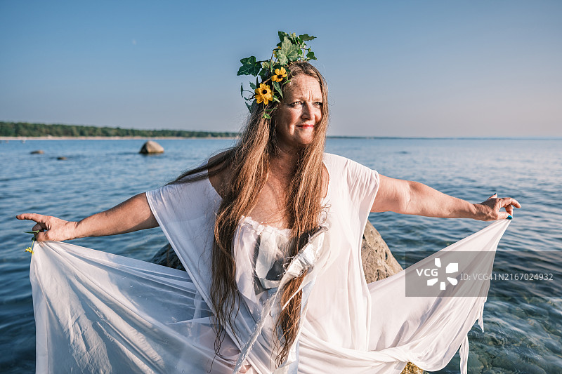 夕阳下沙滩上的成熟的女人图片素材