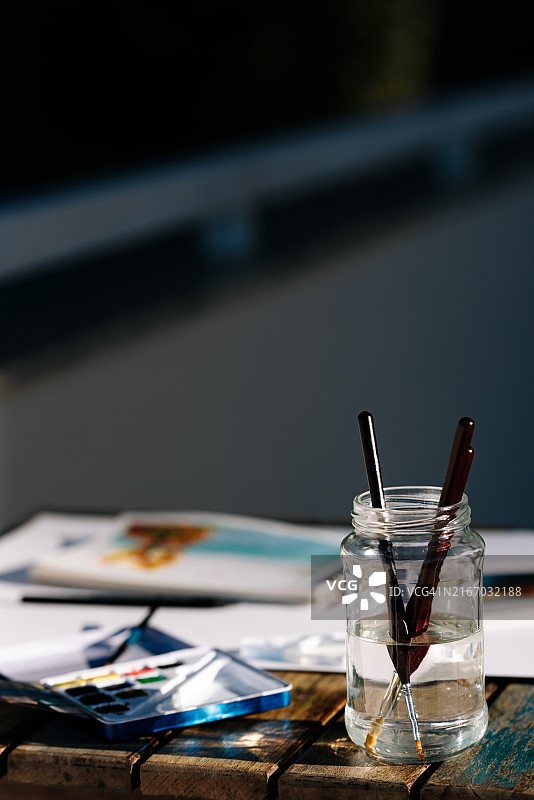 水彩画笔水罐阳光木桌场景图片素材